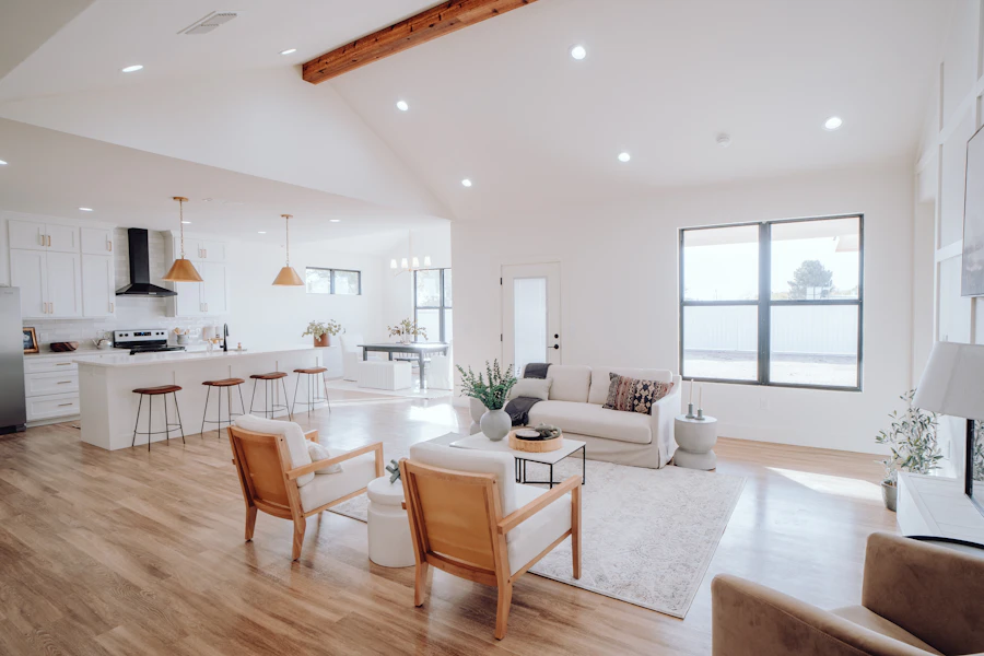 A bright, open-plan living room and kitchen with polished wood floors